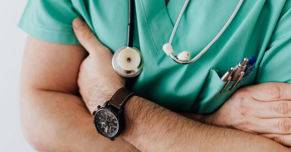 Doctor in scrubs with folded arms and stethoscope, symbolizing confidence in healthcare.